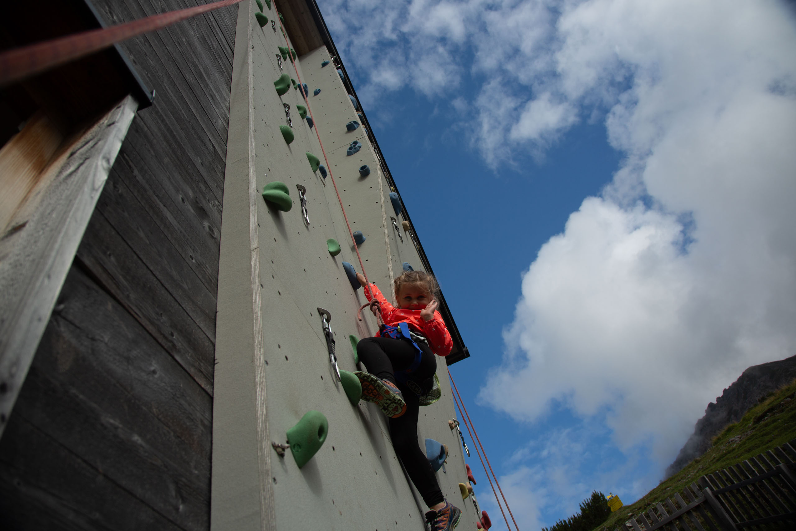 Mädchen klettert auf der Kletterwand empor