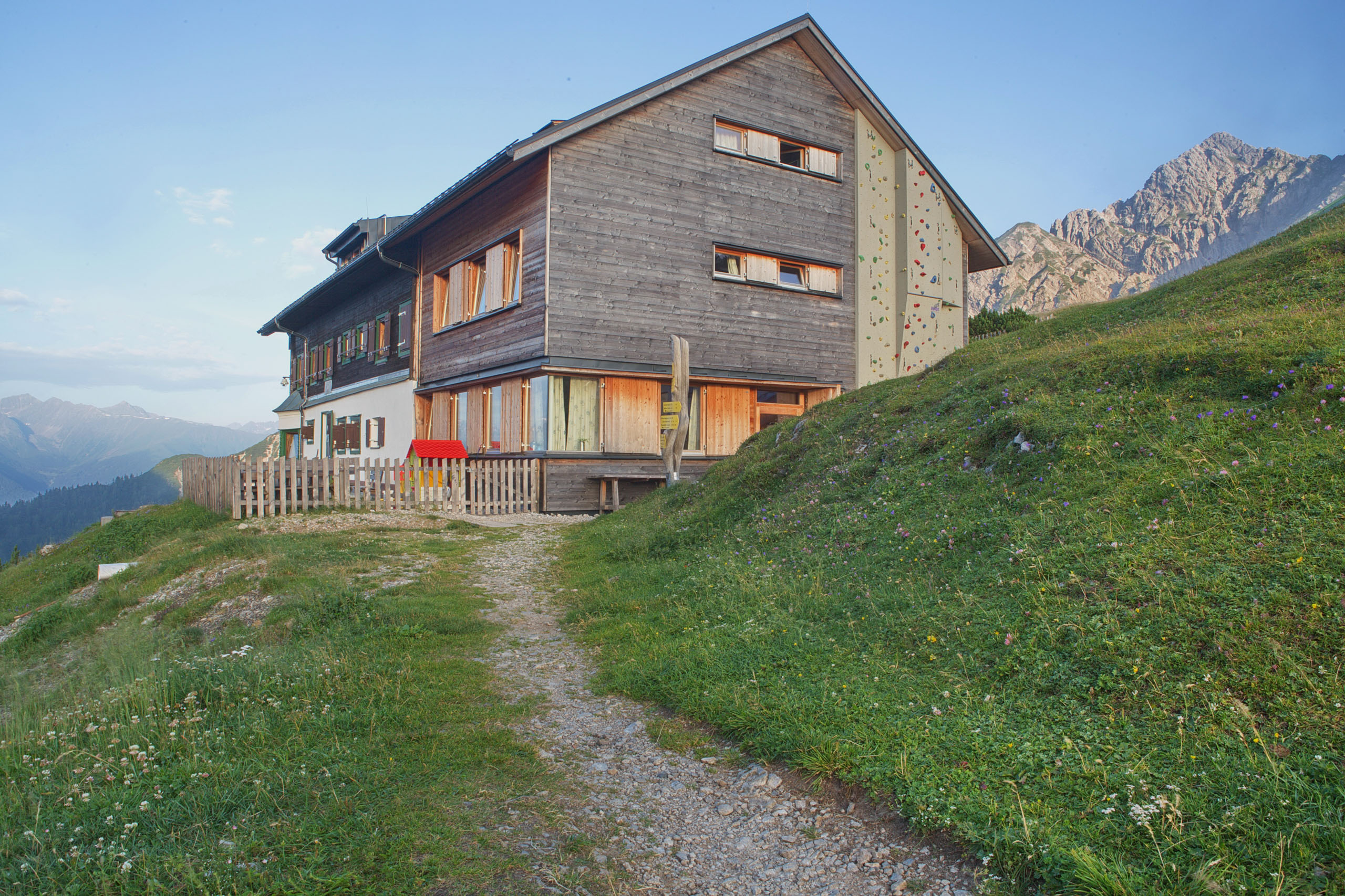 Rückseite vom Solsteinhaus mit Kletterwand und Terrasse